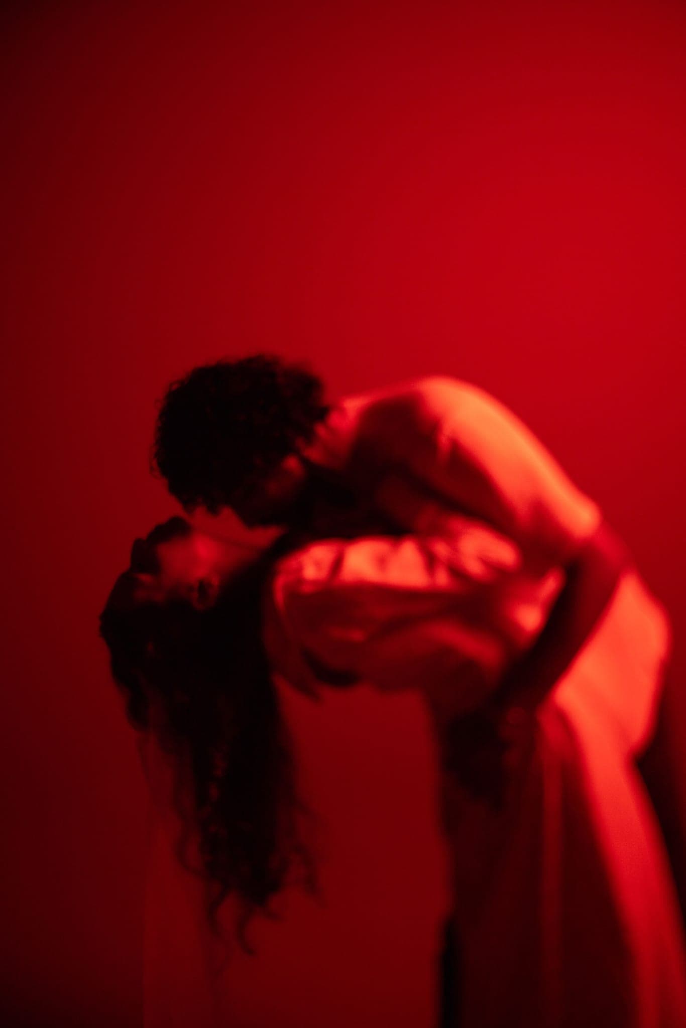Couple embracing bathed in dramatic red light