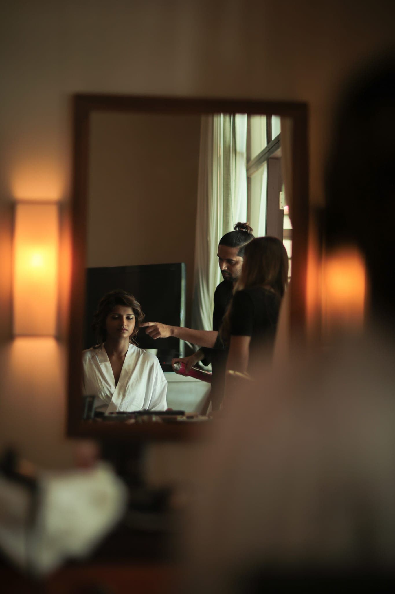 Bride reflected in mirror during hair styling session