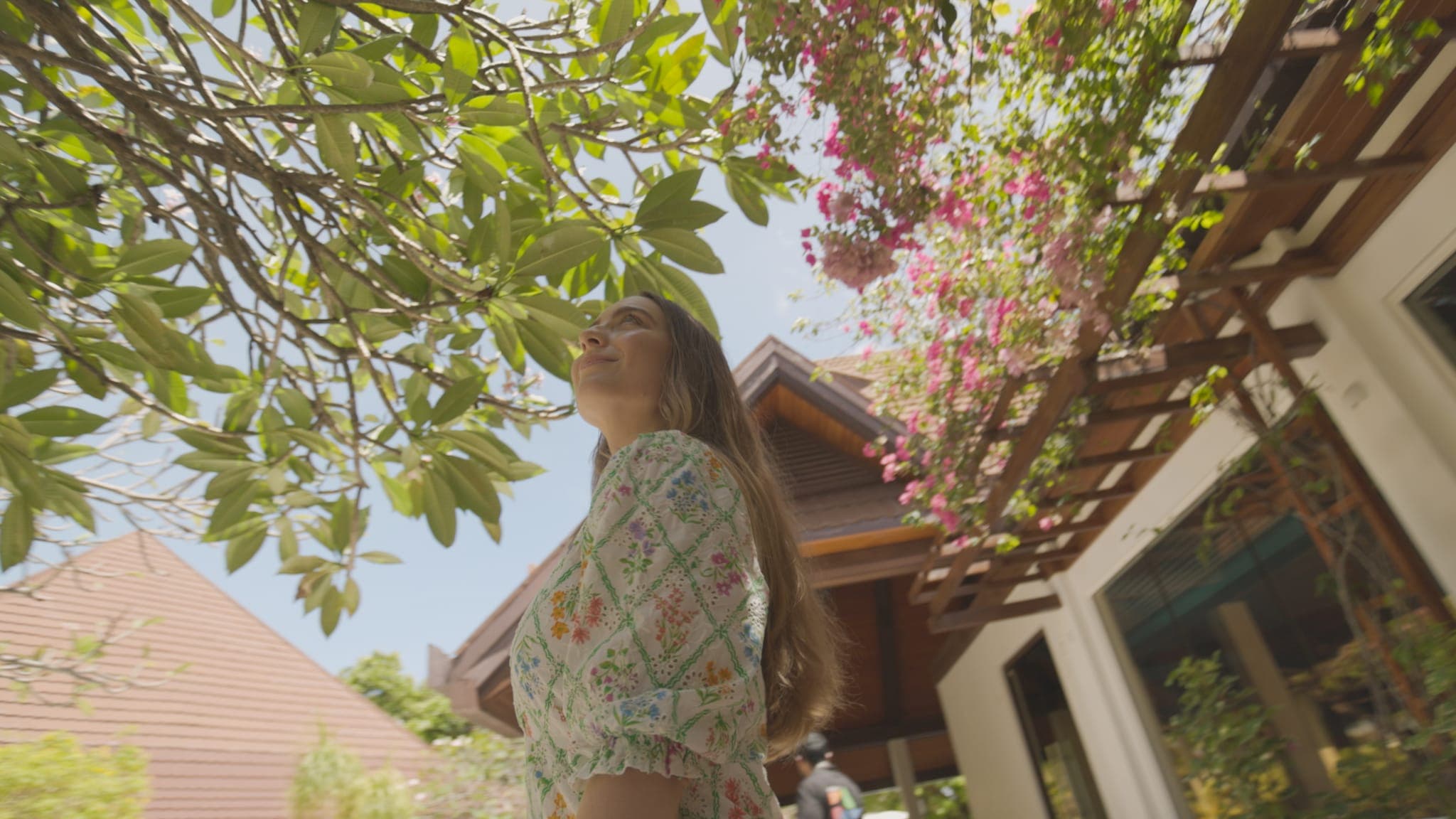 Woman standing under blossoming tree in garden