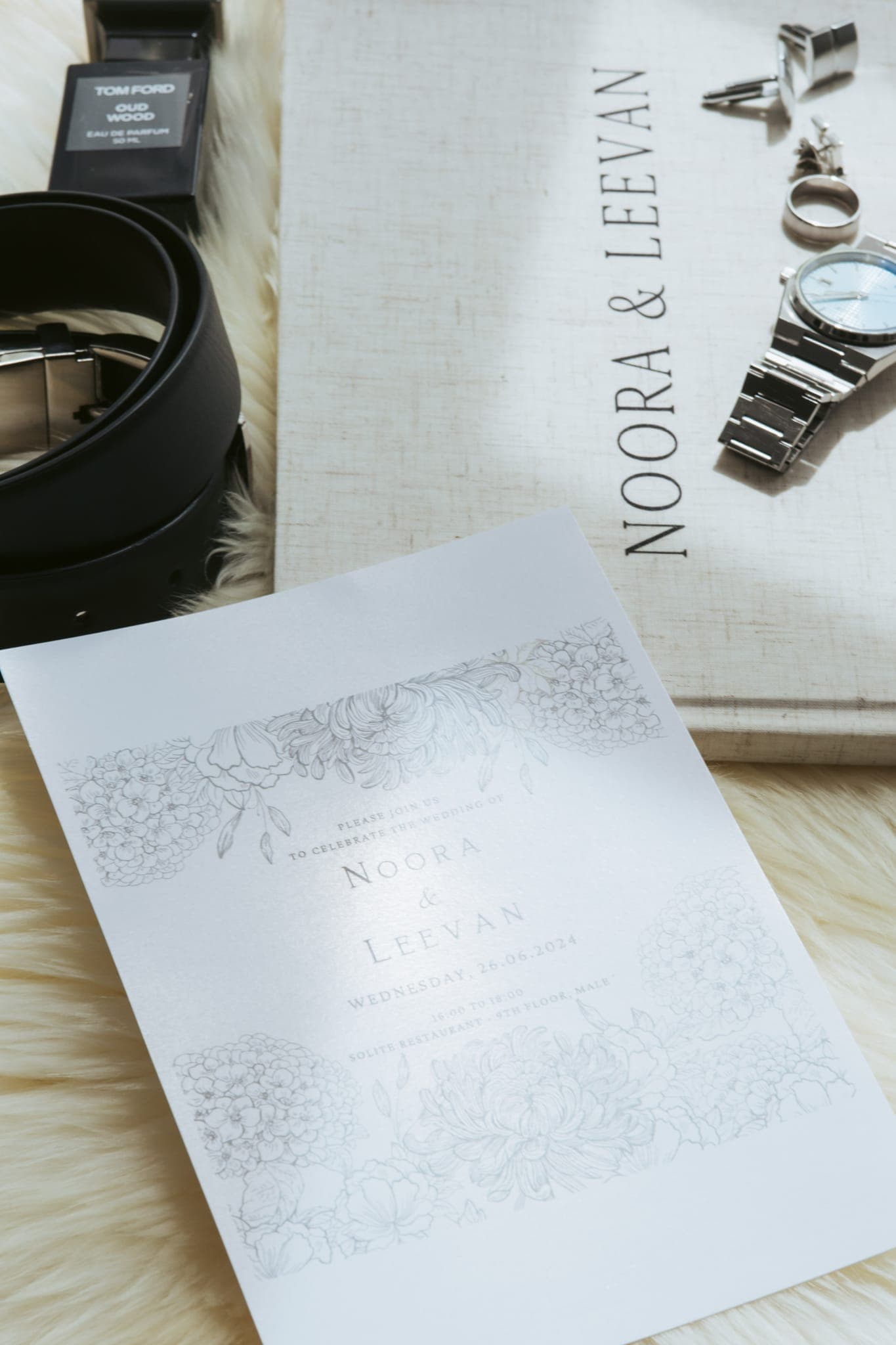 Groom's watch, belt and invitation card flatlay