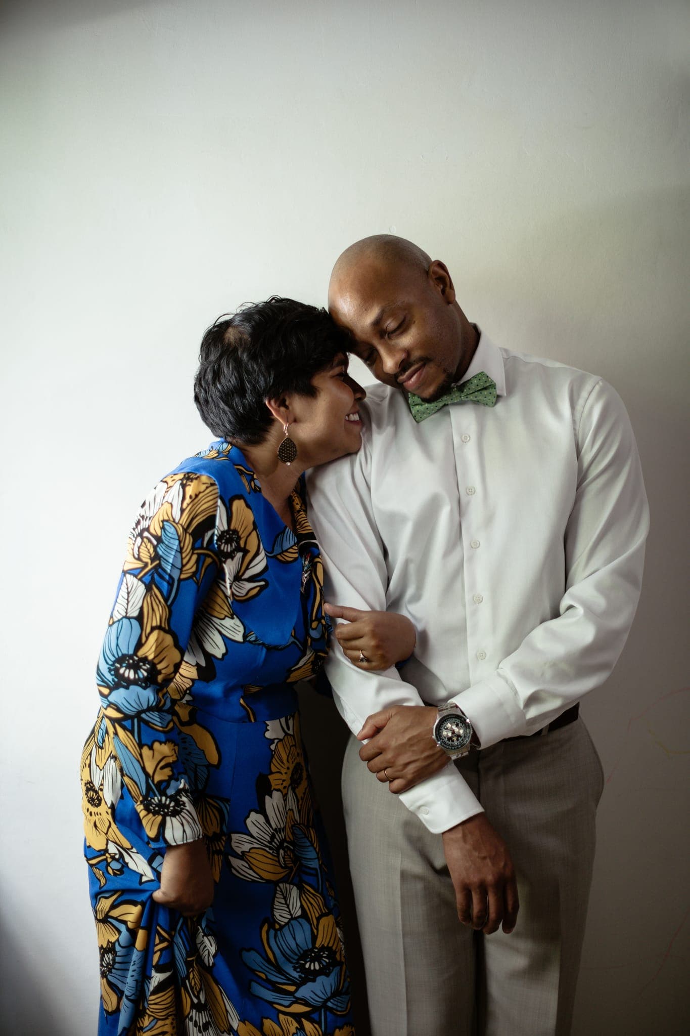 Couple in patterned outfits smiling affectionately indoors
