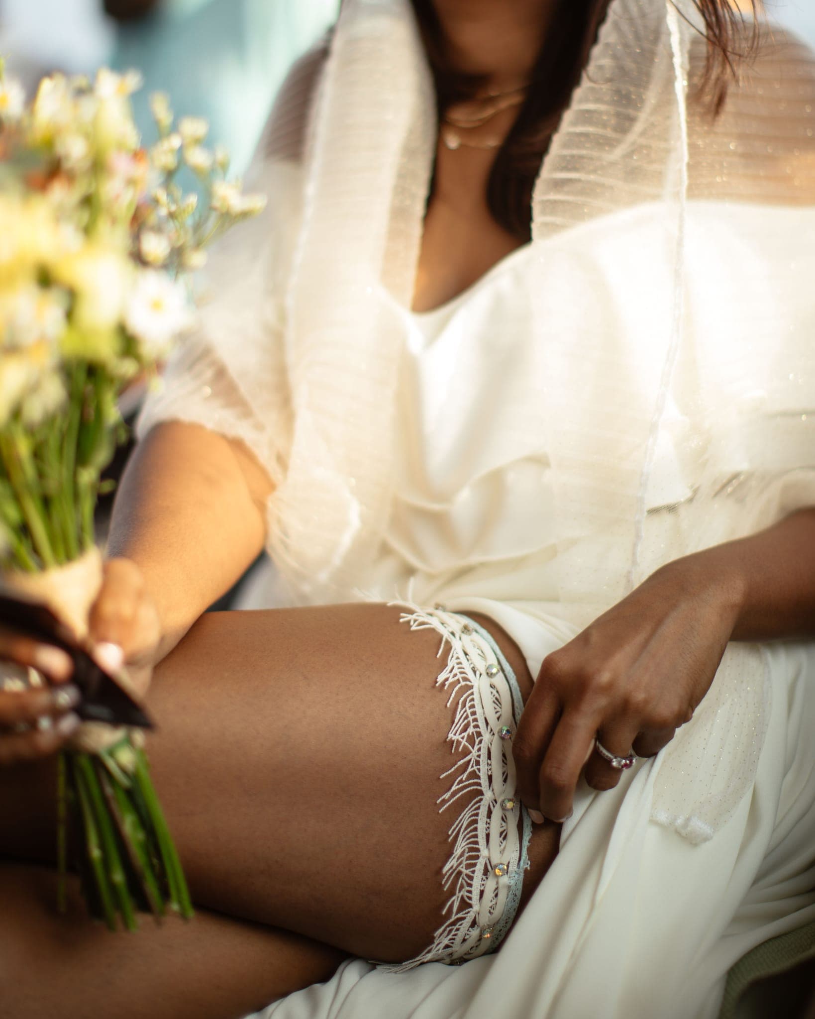 Close-up of bride's lace garter and bouquet detail