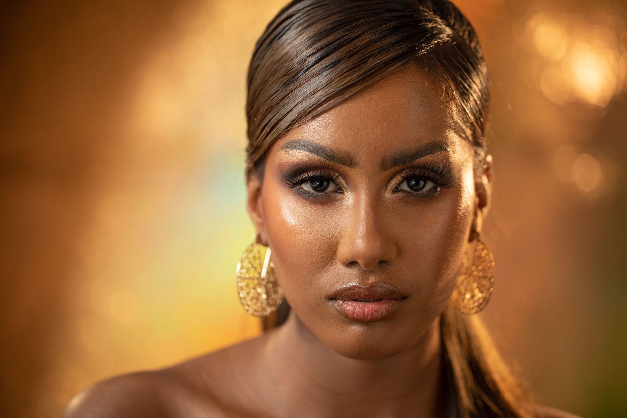 Close-up beauty portrait of woman with gold earrings and makeup