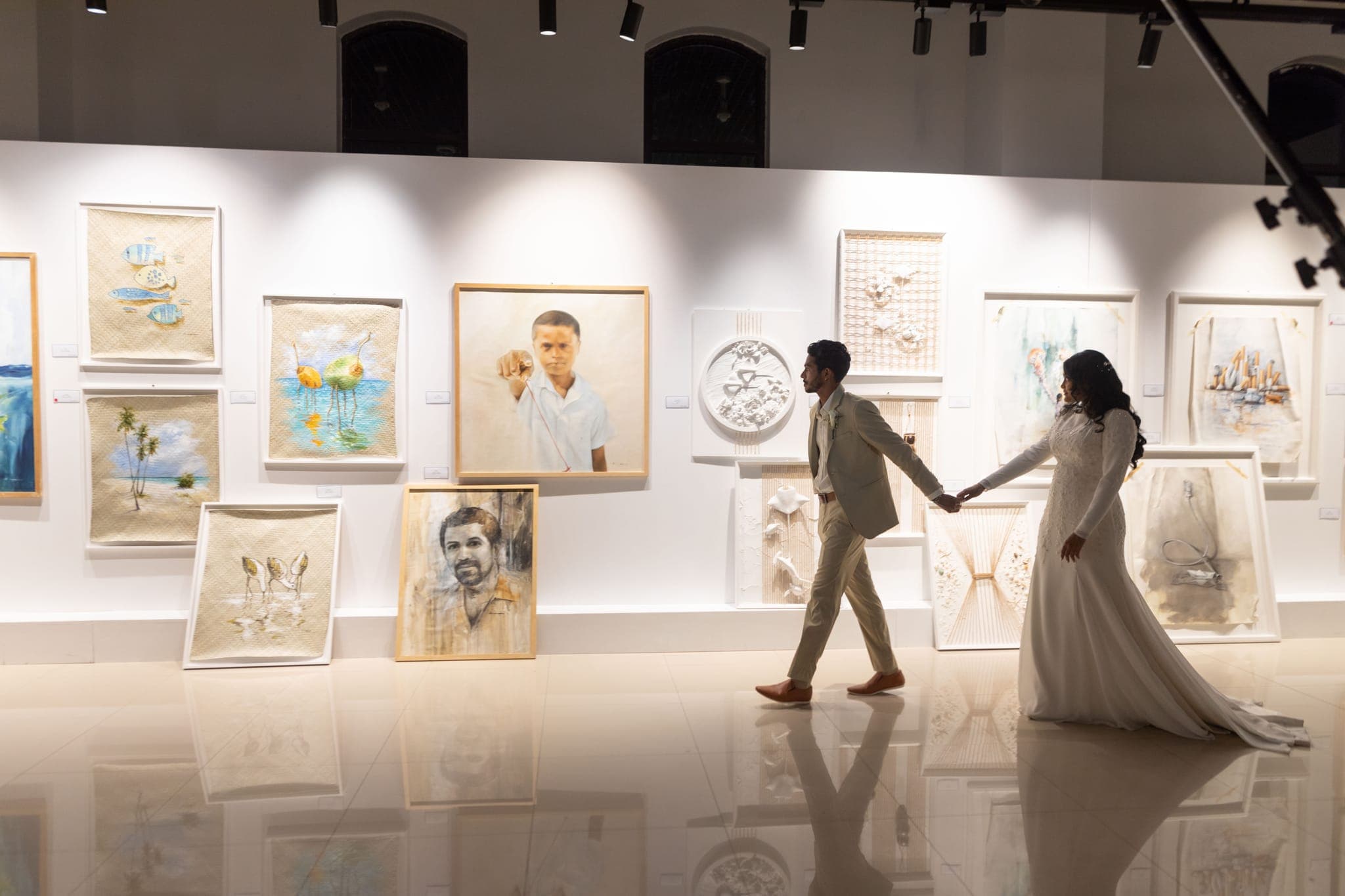 Couple holding hands walking through art gallery exhibit