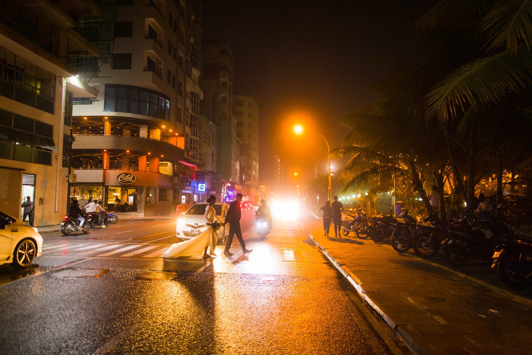 Blurry night street scene with car headlights and people