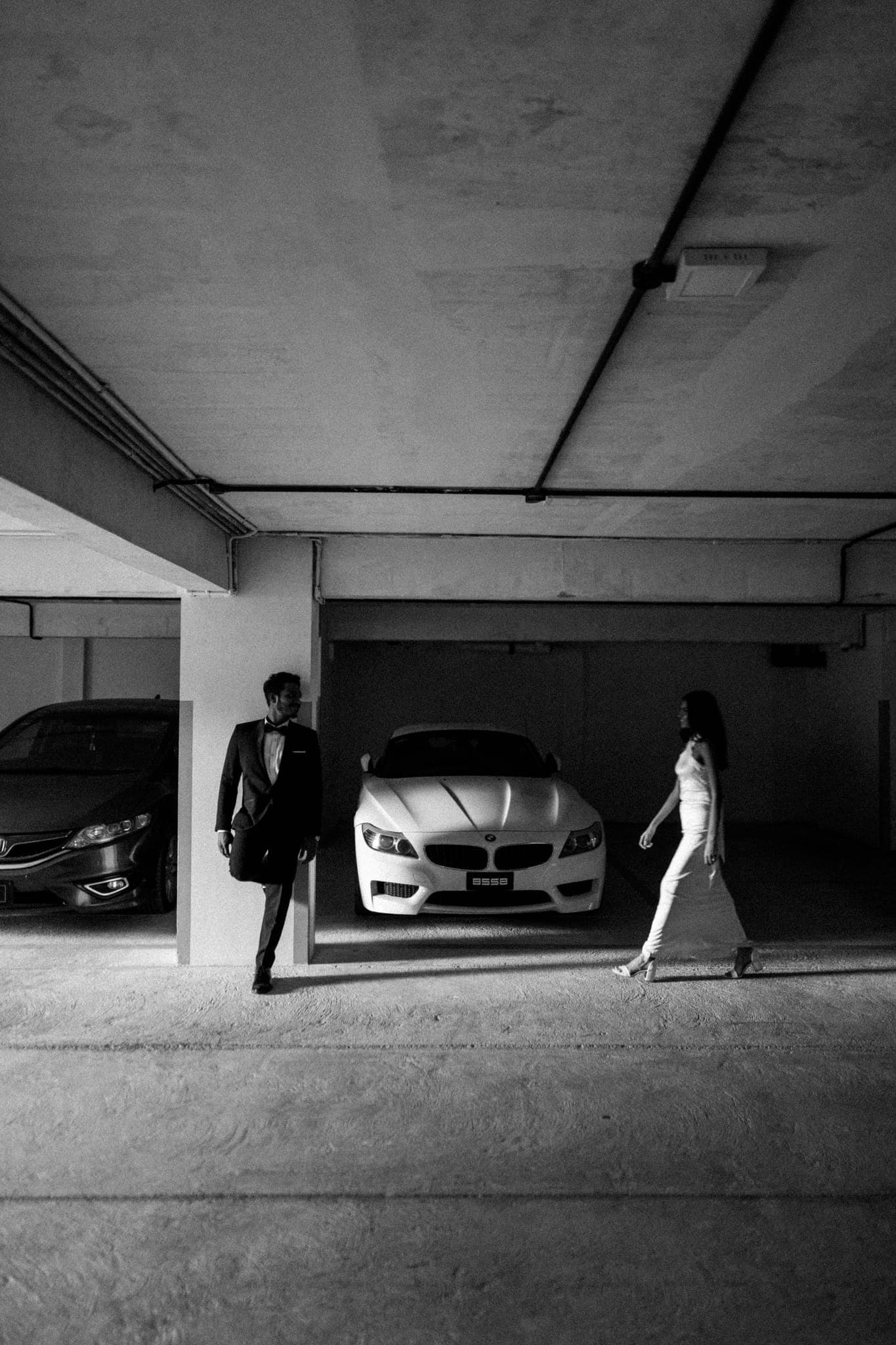 Couple silhouetted walking through sunlit parking garage
