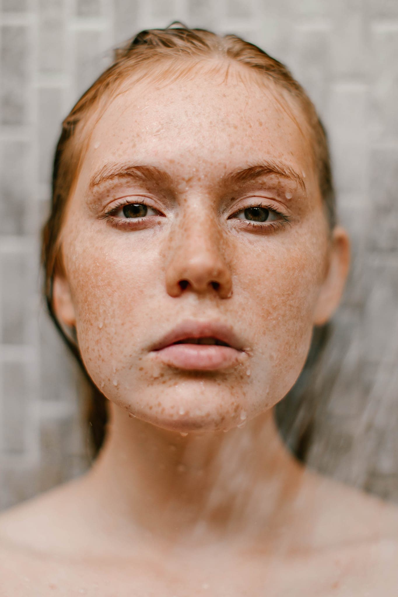 Close-up portrait of freckled woman with wet hair