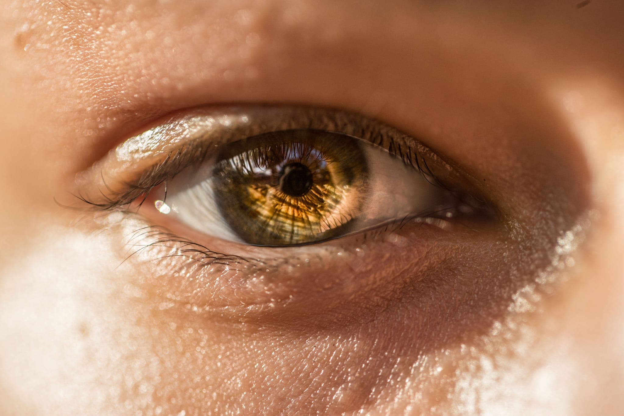 Extreme close-up of hazel eye with sunlight