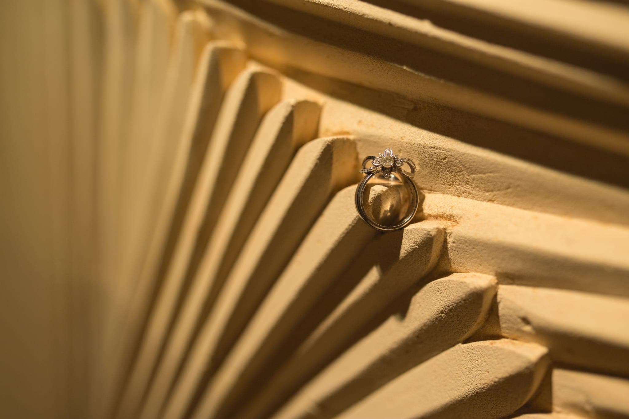 Wedding ring resting on folded fan detail shot