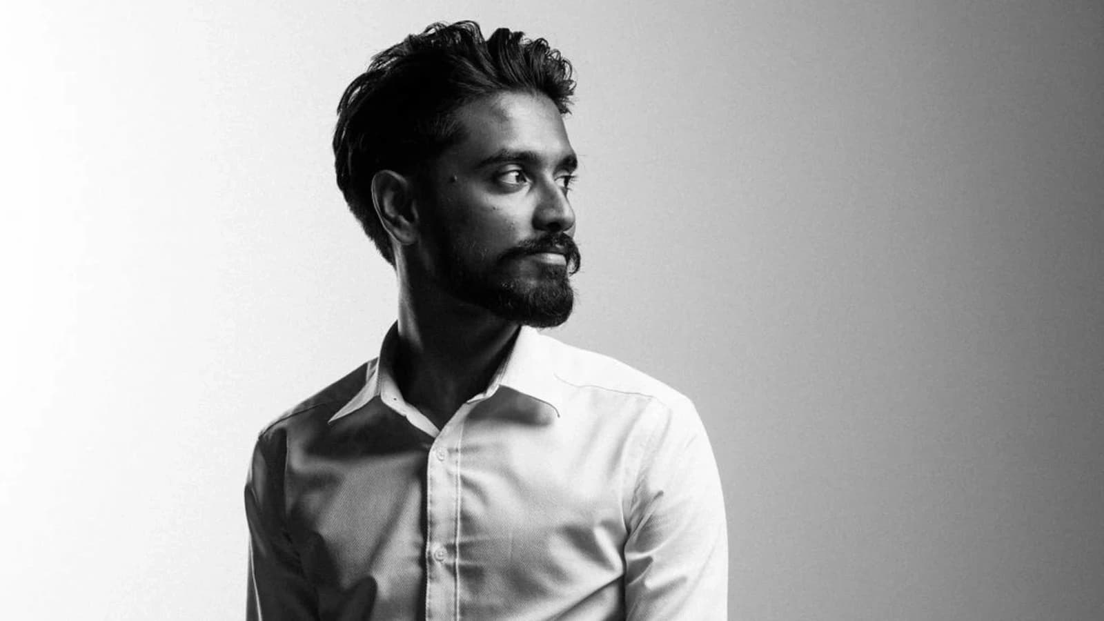 A black-and-white portrait against a bright Studio7 backdrop.